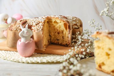 Lezzetli İtalyan Paskalya güvercini pastası (geleneksel Colomba di Pasqua) ve beyaz ahşap masa üzerindeki şenlikli dekor