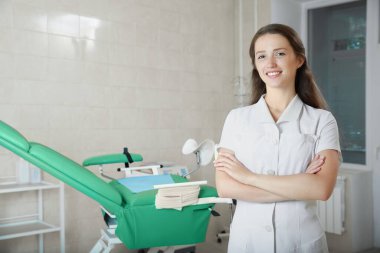 Klinikteki iş yerinde gülümseyen genç bir jinekologun portresi. Metin için boşluk