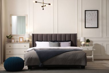 Şık bir yatak odası, geniş konforlu yatak odası ve çekmeceler.