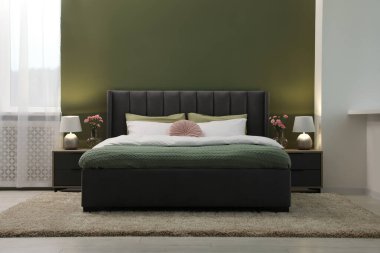 Lüks bir odada büyük, rahat bir yatak, lambalar ve güzel çiçekler. İç tasarım