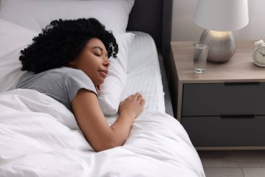 Evdeki yumuşak yatakta uyuyan güzel bir genç kadın.