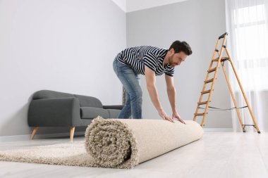 Odada yeni temiz halı seren bir adam