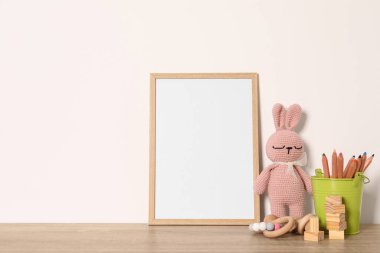 Boş kare çerçeve, kırtasiye ve ahşap masada farklı oyuncaklar, metin için boşluk