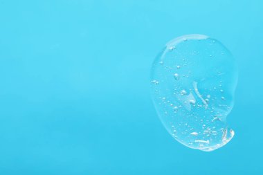 Açık mavi arkaplanda temizleyici jel örneği, üst görünümde metin için boşluk. Kozmetik ürünü