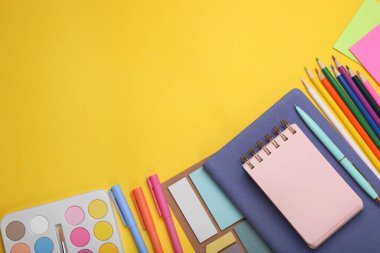 Flat lay composition with different school stationery on yellow background, space for text. Back to school