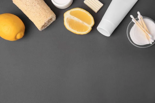 Lemon face wash. Fresh citrus fruits and personal care products on dark grey background, flat lay. Space for text