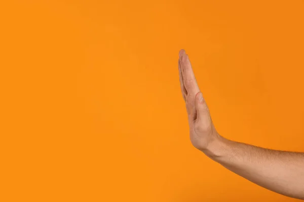 Mężczyzna Pokazuje Gest Stop Pomarańczowym Tle Zbliżenie Miejsca Tekst — Zdjęcie stockowe