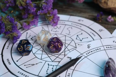 Zodyak tekerlekleri, çiçekler ve astroloji zarları ahşap masada, yakın plan.