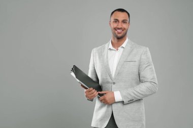 Gri arka planda dosyaları olan genç bir iş adamı. Metin için boşluk