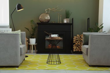 Güzel şömine, koltuklar, masa ve oturma odasındaki farklı dekorlar. İç tasarım