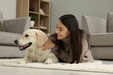 Evde şirin Labrador Retriever köpeği olan mutlu bir kadın. Sevimli hayvan.