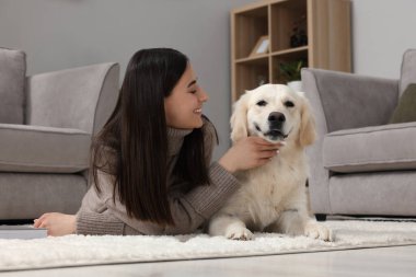 Evde şirin Labrador Retriever köpeği olan mutlu bir kadın. Sevimli hayvan.