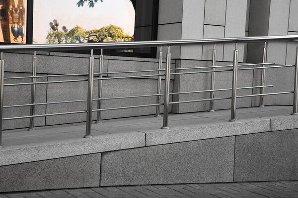 Ramp with metal handrails near building outdoors