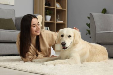 Evde şirin Labrador Retriever köpeği olan mutlu bir kadın. Sevimli hayvan.
