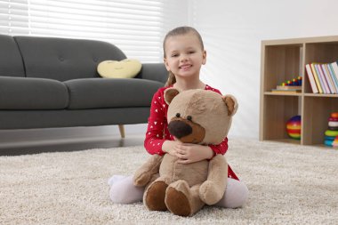 Evde oyuncak ayı ile oynayan sevimli küçük kız