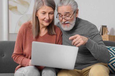 Dizüstü bilgisayarlı yaşlı çift odada emeklilik planlarını tartışıyor