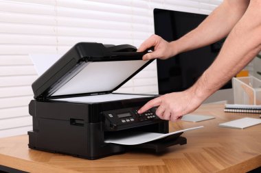 Ahşap masada modern yazıcı kullanan bir adam, yakın plan.