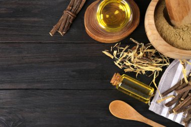 Kurumuş meyan kökü çubukları, talaşlar ve siyah ahşap masa üzerinde gerekli yağ, düz yatıyordu. Metin için boşluk