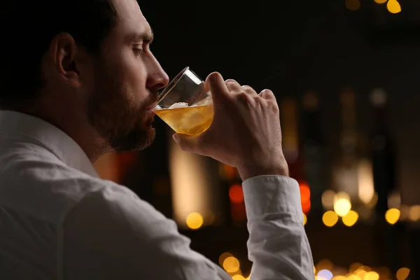 Schöner Mann Trinkt Whiskey Gegen Verschwommenes Licht — Stockfoto