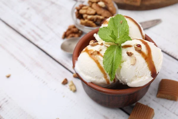 Mísa Chutné Zmrzliny Karamelovou Omáčkou Mátou Ořechy Bílém Dřevěném Stole — Stock fotografie
