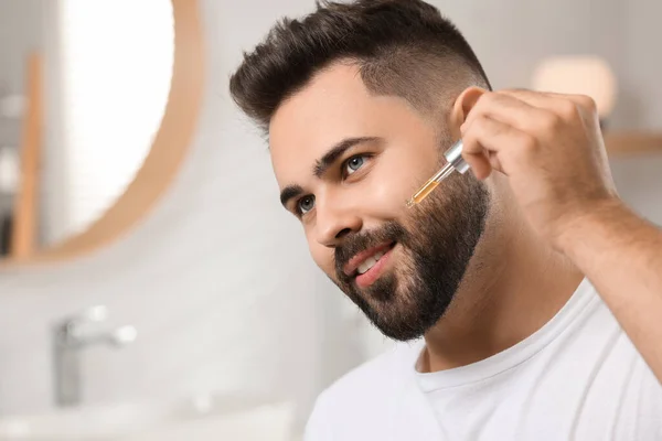 Schöner Mann Der Badezimmer Kosmetikserum Auf Sein Gesicht Aufträgt — Stockfoto