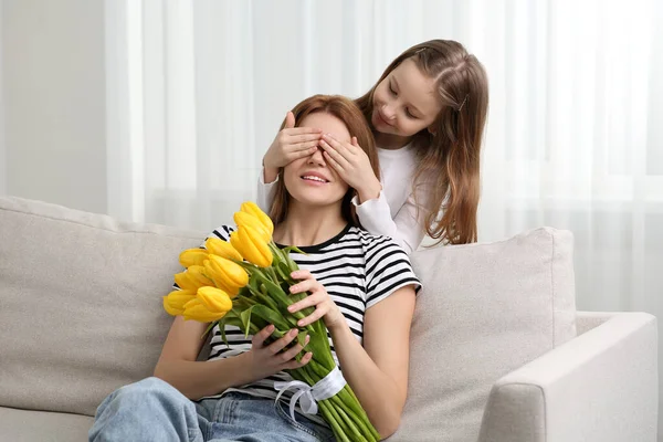 Dcera Zakrývající Matčiny Oči Dlaněmi Blahopřející Kytici Žlutých Tulipánů Doma — Stock fotografie