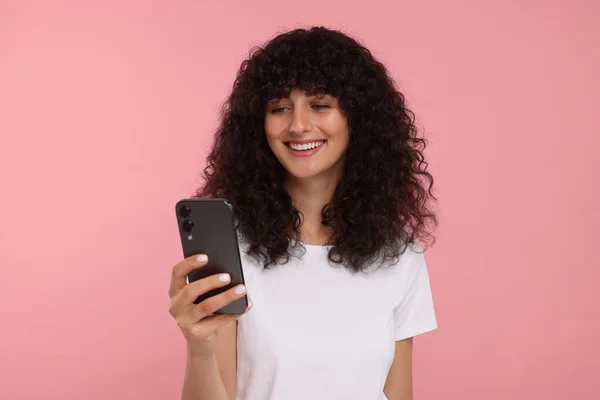 Ευτυχισμένη Νεαρή Γυναίκα Κοιτάζοντας Smartphone Ροζ Φόντο — Φωτογραφία Αρχείου