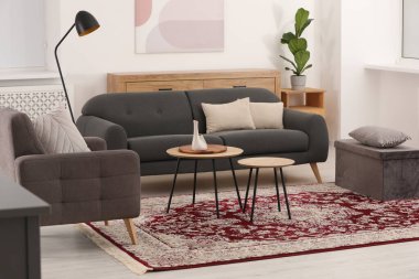 Şık mobilyaları ve güzel desenli yumuşak halısı olan rahat bir oda.