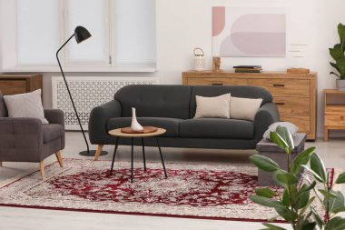 Şık mobilyaları ve güzel desenli yumuşak halısı olan rahat bir oda.