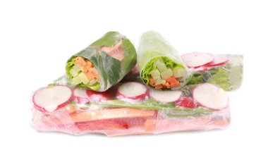 Beyaz arka planda pirinç kağıdına sarılı farklı lezzetli börekler.