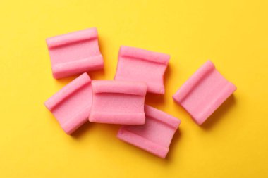 Sarı arka planda leziz pembe sakız, düz uzanmış.