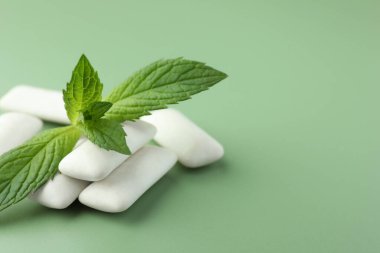 Lezzetli beyaz sakız ve açık yeşil arka planda nane yaprakları, yakın plan. Metin için boşluk