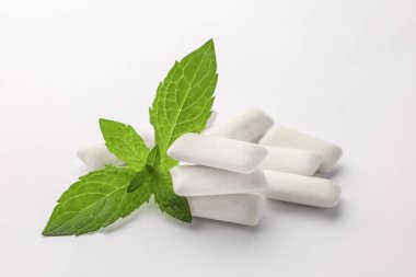 Lezzetli sakız ve nane yaprakları beyaz arka planda, yakın plan