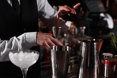 Barmen tezgahta martini bardağında taze alkollü kokteyl hazırlıyor.