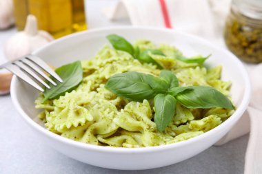 Pesto soslu ve fesleğenli lezzetli makarna, yakın plan.