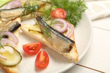 Lezzetli sandviçler, salatalık turşusu, soğan ve dereotu beyaz ahşap masada servis edilir.