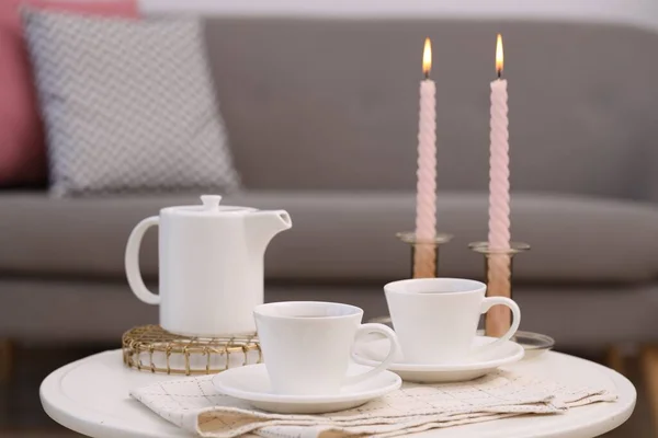 Teetassen Teekannen Und Brennende Kerzen Auf Weißem Couchtisch Drinnen — Stockfoto