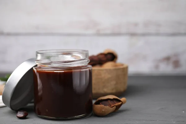 Jar Tasty Tamarind Sauce Fresh Pods Grey Wooden Table Space — Stock Photo, Image