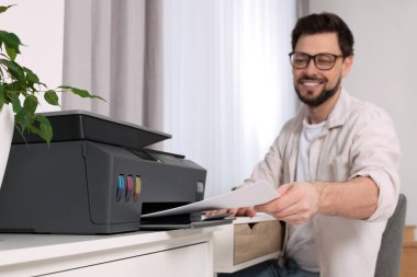 İş yerinde modern yazıcı kullanan adam kapalı alanda, seçici odak