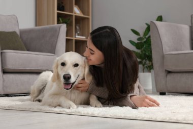 Evde şirin Labrador Retriever köpeği olan mutlu bir kadın. Sevimli hayvan.