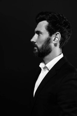 Siyah arka planda sakallı yakışıklı bir adamın profil portresi. Siyah ve beyaz etkisi