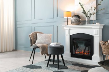 Güzel bir şömine, farklı bir dekor ve oturma odasında koltuk. İç tasarım