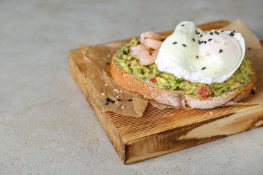 Guacamole soslu lezzetli sandviç, karides ve açık gri masada kızarmış yumurta, yakın plan. Metin için boşluk