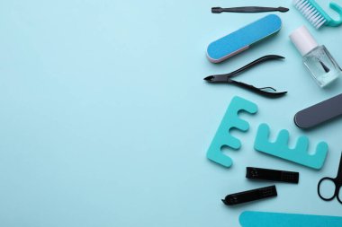 Açık mavi arkaplandaki pedikür aletleri, düz yatış. Metin için boşluk
