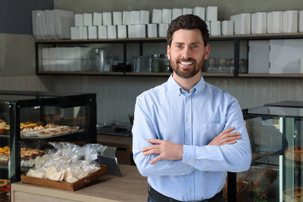 Portrait of happy business owner in bakery shop