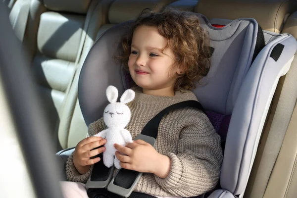 Nettes Kleines Mädchen Mit Spielzeugkaninchen Kindersitz Auto — Stockfoto