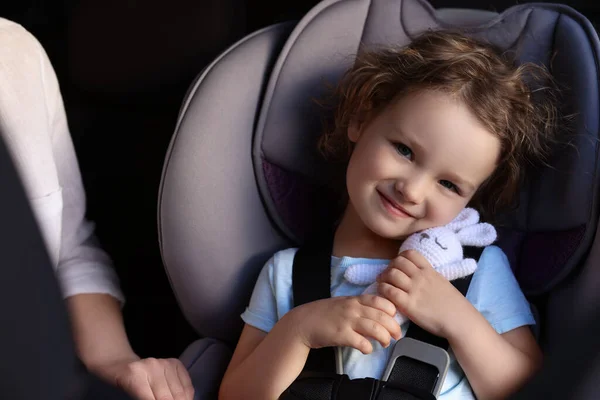 Nettes Kleines Mädchen Mit Spielzeugkaninchen Kindersitz Neben Mutter Auto — Stockfoto
