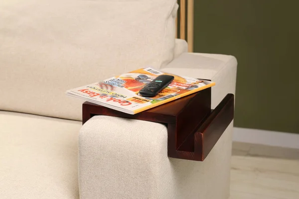 房间里沙发扶手木桌子上的杂志和遥控器 内政部分 — 图库照片