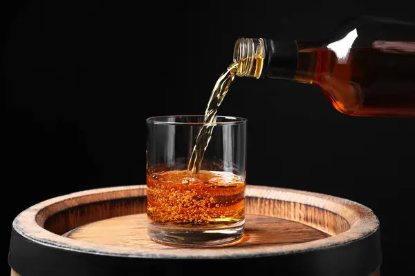 Whisky Uit Fles Gieten Glas Houten Vat Tegen Zwarte Achtergrond — Stockfoto