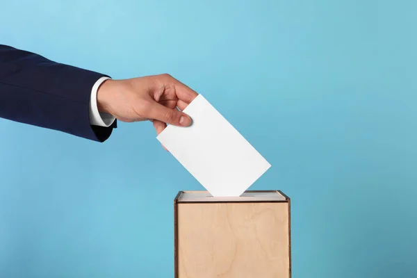 Man Putting His Vote Ballot Box Light Blue Background Closeup — Stock Photo, Image